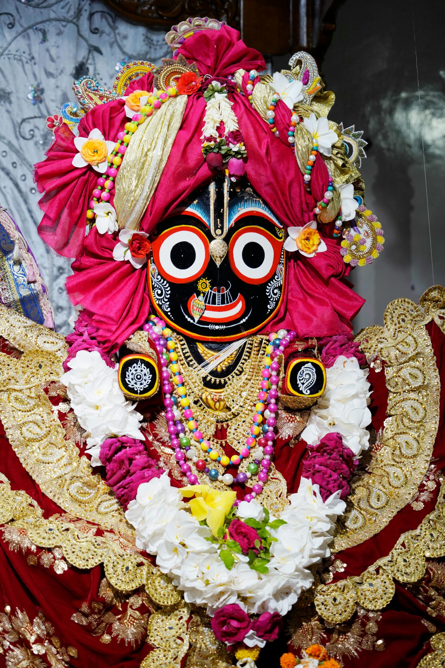 Colorful and intricate statue of Lord Jagannath adorned with flowers at ISKCON Dhaka Swamibag Temple, Bangladesh.
